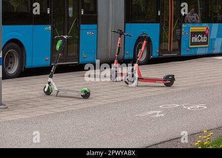 Göteborg, Schweden - Mai 16 2021: Elektrische Roller aus Lime und VOI parken an einer Bushaltestelle. Stockfoto