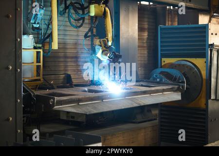 Automatisierte Industriemaschine beim Lichtbogenschweißen und bei der Erstellung neuer Artikel in einer großen Werkstatt einer Maschinenproduktionsanlage Stockfoto