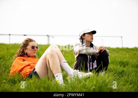 Ceylon Andi Hickman und Lucy „Monki“ Monkman auf einem grasbedeckten Hügel, die ein Spiel der Dulwich Hamlet FC Women sehen. Stockfoto