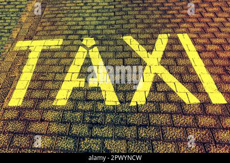 TAXIAUFSCHRIFT auf dem Bürgersteig. Taxiparkplätze auf der Straße der Stadt Stockfoto