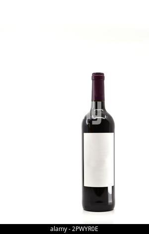 Ungeöffnete Flasche Rotwein mit leerem Etikett, isoliert auf weißem Hintergrund. Speicherplatz links und darüber kopieren. Stockfoto