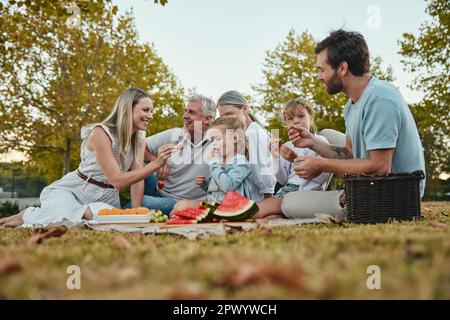 Wassermelone, Liebe oder große Familie in der Natur auf einem Picknick gesunde Früchte oder Essen im Sommerurlaub in Berlin. Großeltern, Mutter und glücklich Stockfoto