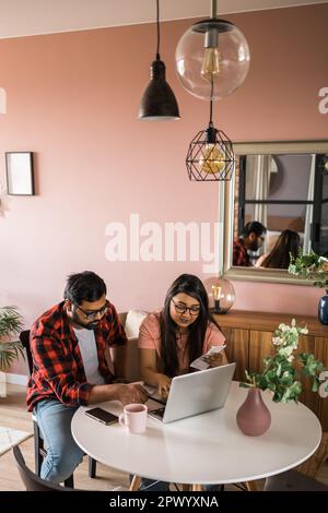 Ernsthafte Ehefrau und Ehemann planen Budget, prüfen Finanzen, fokussierte junge Frau mit Online-Rechner und Zählen von Rechnungen oder Steuern, Mann mit Laptop Stockfoto