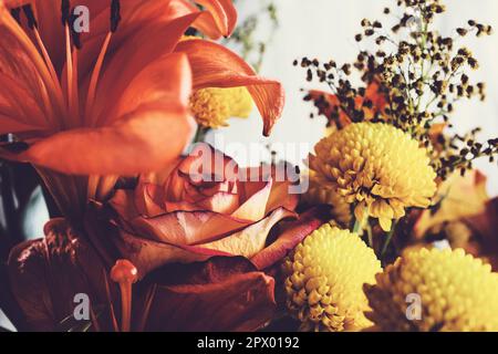 Blick auf einen wunderschönen Blumenstrauß mit orangefarbenen Lilien, Rosen und gelbem Chrysanthemum. Stockfoto