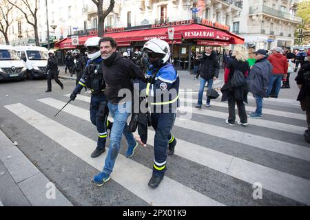 1. Mai 2023 Demonstranten und französische Polizei treffen sich während der Bürgerkriegsaufstände am 1. Mai 2023 im Zentrum von Paris. Viele kamen zu Wort, um ihre Abneigung gegen Präsident Macron und seine derzeitige Politik zum Ausdruck zu bringen. Zwei Polizeibeamte verhaften den Demonstranten während der Mayday-Demonstration in Paris. Stockfoto