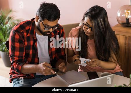 Ernsthafte Ehefrau und Ehemann planen Budget, prüfen Finanzen, fokussierte junge Frau mit Online-Rechner und Zählen von Rechnungen oder Steuern, Mann mit Laptop Stockfoto
