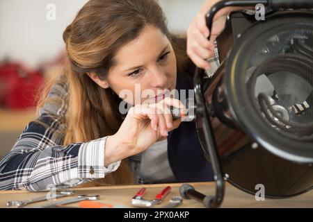 Weibliche Ingenieurin, die tragbare Heizgeräte repariert Stockfoto