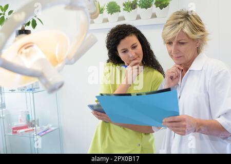 Zahnarzt und Assistent beim Betrachen von Röntgenaufnahmen Stockfoto