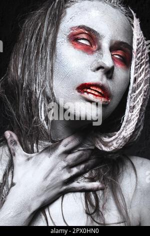 Ein Mädchen in Form von Zombies, eine Halloween-Leiche mit Blut auf seinen Lippen. Bild für einen Horrorfilm. Im Studio aufgenommene Fotos Stockfoto