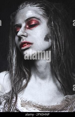 Ein Mädchen in Form von Zombies, eine Halloween-Leiche mit Blut auf seinen Lippen. Bild für einen Horrorfilm. Im Studio aufgenommene Fotos Stockfoto