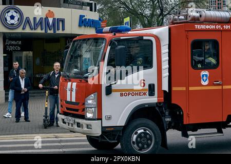 Voronesch, Russland. 01. Mai 2023. Feuerwehrauto am Scheideweg zum Arbeitersolidaritätstag in Voronesch. Ende April bereiten sich russische Städte auf die Feiertage im Mai vor. Der wichtigste dieser Feiertage ist der Siegesfeiertag der UdSSR über Nazideutschland. Die Straßen von Voronesch Ende April waren mit roten Flaggen und Plakaten geschmückt, die den Krieg in der Ukraine unterstützten. Die Menschen führten ihr tägliches unpolitisches Leben fort. (Foto: Mihail Siergiejevicz/SOPA Images/Sipa USA) Guthaben: SIPA USA/Alamy Live News Stockfoto