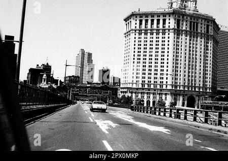 AJAXNETPHOTO. JULI 1975. NEW YORK, USA. - UNTERE MANHATTAN SKYLINE - VON DER BROOKLYN-BRÜCKE AUS GESEHEN, DIE IN DIE STADT FÜHRT. AUF DER RECHTEN SEITE BEFINDET SICH DAS 40-STÖCKIGE STADTHAUS DAVID N DINKINS, DAS VON MCKIM, MEAD UND WHITE ENTWORFEN WURDE. FOTO: JONATHAN EASTLAND/AJAXREF:232404 103 Stockfoto