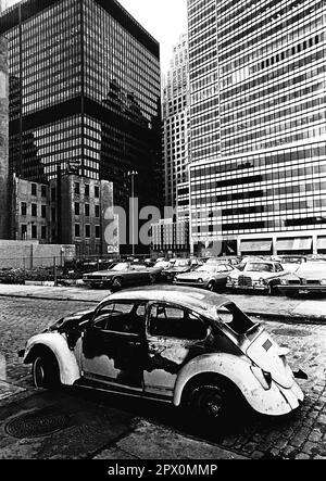 AJAXNETPHOTO. JULI 1975. NEW YORK, USA. - LOWER MANHATTAN - EIN AUSGEBRANNTER VOLKSWAGEN, VERLASSEN AUF DER WASSERSTRASSE, IN RICHTUNG 127 JOHN STREET. FOTO: JONATHAN EASTLAND/AJAXREF:232404 119 Stockfoto