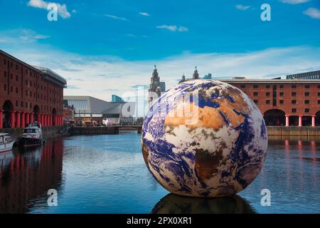Liverpool, Großbritannien. 29. April 2023. Eine riesige Kunstinstallation mit einem Durchmesser von 10m mm Floating Earth vom Künstler Luke Jerram, gesehen im Royal Albert Dock Liverpool mit dem berühmten Liver Building im Blick dahinter. (Foto: Dave Rushen/SOPA Images/Sipa USA) Guthaben: SIPA USA/Alamy Live News Stockfoto