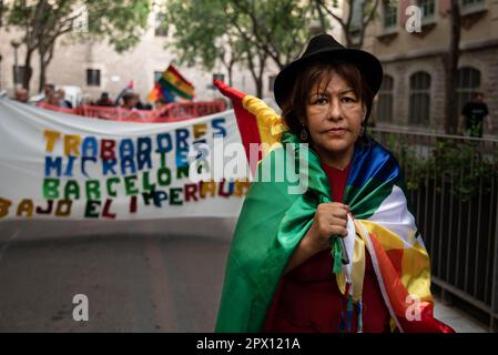 Barcelona, Spanien. 01. Mai 2023. Eine Demonstrantin trägt während des protestmarsches am Arbeitertag anlässlich des Internationalen Arbeitertags in Barcelona eine bolivianische und eine indigene Flagge. Tausende von Menschen aus verschiedenen sozialen Gruppen gingen am Nachmittag des Montag, den 1. Mai, auf die Straßen im Herzen von Barcelona, um zum Arbeitertag zu demonstrieren. Kredit: SOPA Images Limited/Alamy Live News Stockfoto