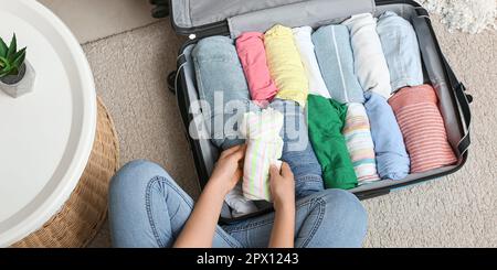 Eine Frau, die zu Hause Koffer packt, Draufsicht Stockfoto