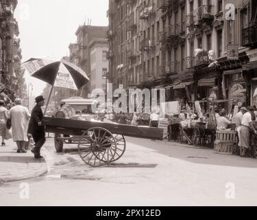 1930S PUSH-CART-VERKÄUFER VERKAUFEN ALLES LEBENSMITTEL OBST UND GEMÜSE KLEIDUNG STOFFSCHUHE LOWER EAST SIDE NEW YORK CITY NY USA - M3464 HAR001 HARS PERSONS MALERISCHE LÄDEN UNITED STATES OF AMERICA MÄNNERGEBÄUDE NY TRANSPORT B&W NORTH AMERICA SHOPPER EINKÄUFER AUS NORDAMERIKA, DIE IN DER NACHBARSCHAFT ABENTEUEROBJEKTE VERKAUFEN, KUNDENSERVICE UND NETWORKING-AUFREGUNG AUSSENVERKÄUFER LES OPPORTUNITY NYC OCCUPATIONS STORES IMMOBILIEN BÜRGERSTEIGE NEW YORKER BAUTEN STÄDTE GEBÄUDE NEW YORK CITY SCHUBKARREN FEUER ENTKOMMT WOHNUNGEN HANDEL ALLES OBST PUSHCART SCHWARZ-WEISS Stockfoto