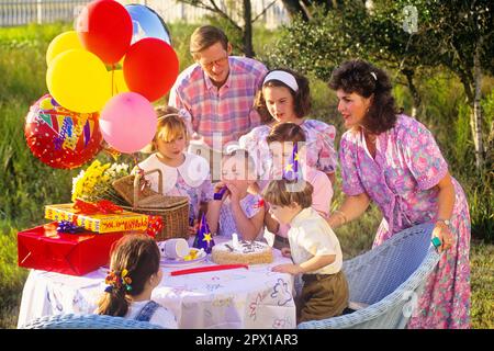 1980S 1990S GEBURTSTAGSJUNGE IM FREIEN, DER DIE KERZEN AUSBLÄST, BUNTE BALLONS UND EINGEPACKTE GESCHENKE AUF DEM TISCH - KS32156 LAF002 HARS MOM STORY UMFASSTE NOSTALGISCHE GEMEINDE VORSTADTFARBE MÜTTER AUS DER ALTEN ZEIT ÜBERRASCHUNG NOSTALGIE BRUDER ALTE MODE SCHWESTER JUGENDKOMMUNIKATION FREUND FREUDE LEBENSSTIL FEIER FRAUEN VERHEIRATET BLOWBRÜDER EHEPARTNER EHEMÄNNER ZUHAUSE KOPIEREN WELTRAUMFREUNDSCHAFT HALBE LÄNGE DAMEN PERSONEN INSPIRATION MÄNNCHEN GESCHWISTER GESCHWISTER VÄTER EHEMANN UND EHEPARTNER EHEMÄNNER UND EHEFRAUEN VATERSCHAFT GLÜCKSELIGKEIT, HOCHWINKEL UND VÄTER AUFREGUNG FAMILIENWERTE Stockfoto