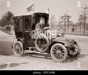 1910S RENAULT AG FRANZÖSISCHES TAXI DE LA MARNE, DAS WÄHREND DES ERSTEN WELTKRIEGS IN PARIS BENUTZT WURDE UND SOWOHL FRANZÖSISCHE ALS AUCH AMERIKANISCHE FAHRZEUGE AUSSTELLTE FLAGGEN - M1339 HAR001 HARS LIFESTYLE GESCHICHTE KONFLIKTE JOBS KOPIEREN WELTRAUMFREUNDSCHAFT HALBE LÄNGE PERSONEN INSPIRATION AUTO MÄNNER TRANSPORT EUROPA B&W FREIHEIT QUALIFIKATION BERUF ABENTEUER EUROPÄISCHE STRATEGIE KUNDENSERVICE UND AUTOS NETZWERKE AUSSENWELT WELTKRIEGE INNOVATION STOLZ WELTKRIEGSCHANCEN BERUFE VERWENDET DE AUTOS RENAULT SUPPORT VEHICLES MARNE SOLUTIONS WORLD WAR ONE WW1 1917 SCHWARZWEISS KAUKASISCHE VOLKSZUGEHÖRIGKEIT AUSSTELLUNGEN HAR001 LA ALTMODISCH Stockfoto