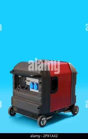 Tragbarer Benzingenerator auf blauem Hintergrund Stockfoto