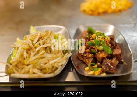 Auf dem Nanjichang Night Market, Taipei, Taiwan, werden im Stil einer Ausstellung kochte Gerichte auf einer heißen Platte serviert Stockfoto