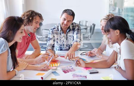 Die Wahl des perfekten Farbtons. Eine Gruppe von Innenarchitekten, die in ihrem Atelier über Farben entscheiden. Stockfoto