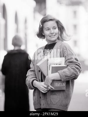 1960S 1970S LÄCHELNDES STUDENTENKIND, DAS EINE ARMVOLL BÜCHER IN SCHULBÜCHERN HÄLT UND EINEN SPERRIGEN PULLOVER TRÄGT, DER ZUR SEITE BLICKT - S19244 HAR001 HARS CAMPUS WEIBCHEN SIEGER GESUNDHEIT KOPIERRAUM HALBE LÄNGE FRAUEN ZUVERSICHT AUSDRUCK B&W ZIELE FRESH DREAMS ZIEMLICH GLÜCKLICH FRÖHLICH UNIVERSITÄTEN STOLZ GESUNDES LÄCHELN HÖHERE BILDUNG LEHRBÜCHER JOYFUL COLLEGES ANGENEHM ANGENEHM ARMSELIG CHARMANTE COED GROWTH LIEBENSWÜRDIGE JUNGE ERWACHSENE FRAU BEZAUBERND ANSPRECHENDE SCHWARZ-WEISSE WEISSE, ETHNISCHE ZUGEHÖRIGKEIT HAR001, DIE AUF DIE SEITE DER ALTMODISCHEN Stockfoto