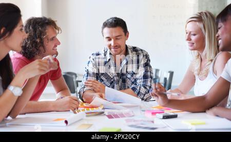 Die Wahl des perfekten Farbtons. Eine Gruppe von Innenarchitekten, die in ihrem Atelier über Farben entscheiden. Stockfoto