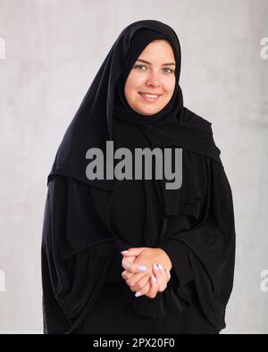 Lächelnde junge Frau in traditioneller islamischer Kleidung Stockfoto
