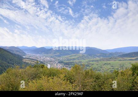 Eine wunderschöne Aussicht auf das Dorf Mezhgorye, Karpaten Region. Eine Menge von Wohngebäuden durch hohe Wald Berge und lange Fluss umgeben Stockfoto