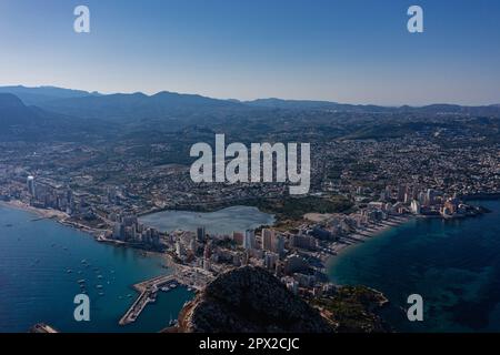Luftaufnahme atemberaubende Penyal dIfac Naturpark von Penon de Ifach massiven Kalkstein auf dem Mittelmeer, vertäute Schiffe im Hafen von Calpe. Sunn Stockfoto
