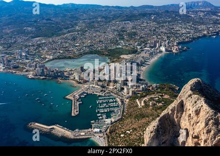 Luftaufnahme atemberaubende Penyal dIfac Naturpark von Penon de Ifach massiven Kalkstein auf dem Mittelmeer, vertäute Schiffe im Hafen von Calpe. Sunn Stockfoto