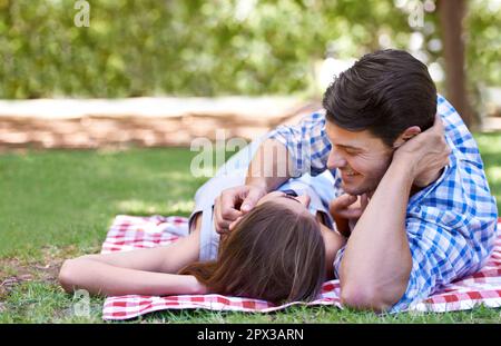 Perfekter Nachmittag. Ein glückliches junges Paar, das ein Picknick in der Sommersonne genießt. Stockfoto