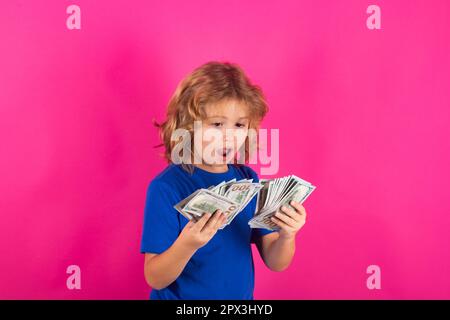 Geldrechnungen, Gehaltszahlungen. Der Junge hat viele hundert Dollar isoliert im Studiohintergrund. Stockfoto