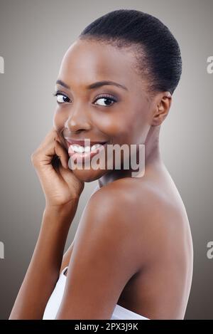 Schönheit kommt ihr ganz natürlich zu... Porträt einer wunderschönen afroamerikanischen Frau, die ihre Haut berührt. Stockfoto