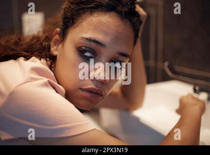 Sieh dir jeden Tag zu, wie du stirbst. Eine junge Frau, die zu Hause im Badezimmer innere Unruhen erlebt Stockfoto