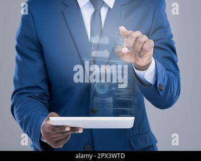 Die Welt in Ihren Händen. Ein unerkannter Geschäftsmann, der sein Tablet benutzt, um eine virtuelle Benutzeroberfläche im Studio vor grauem Hintergrund zu öffnen Stockfoto