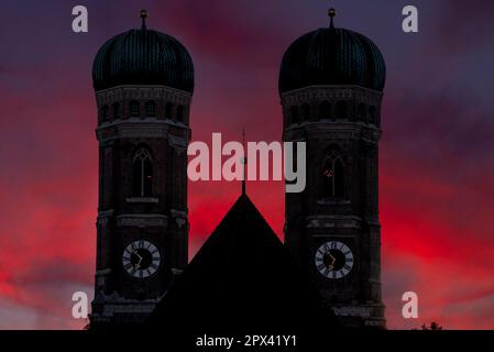 Die Silhouette der beiden Türme der Frauenkirche in München vor dem dramatischen Dämmerhimmel Stockfoto