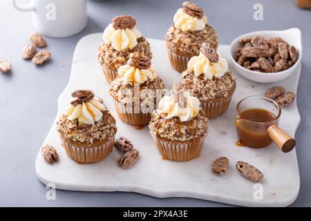 Kürbis Gewürz Karamell Pekannüsse Cupcakes mit Frischkäse-Zuckerguss Stockfoto
