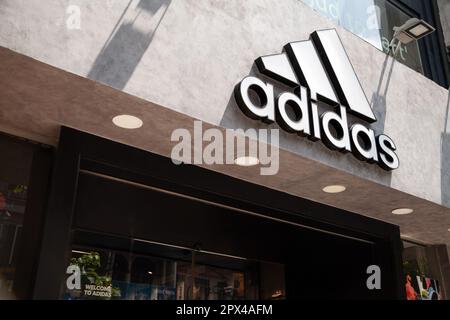 Ho-Chi-Minh-Stadt, Vietnam - 1. Mai 2023: Handelsschild des Sportswear-Shops mit weißem Adidas-Logo. Berühmtes Logo der Sportbekleidungsmarke über einem Geschäft Stockfoto