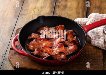 Gebratener Speck in einer gusseisernen Pfanne, fertig zum Frühstücken Stockfoto