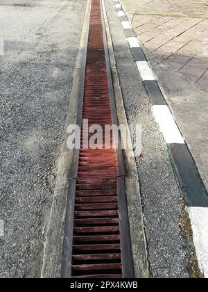 Wasserablauf oder Graben auf der Straße. Regenrinnen, Abflussrost, Abflussabdeckung. Straßenabflüsse - Kanalisationsabdeckung. Ein eiserner Wasserrost auf der Straße in jeder Stadt. Wa Stockfoto
