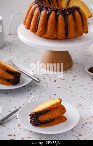 Orangefarbener Pfundkuchen mit dunkler Schokoladenganache und Schokoladenstreuseln Stockfoto