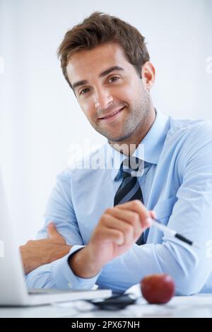 Der moderne Profi. Ein hübscher junger Geschäftsmann bei der Arbeit. Stockfoto