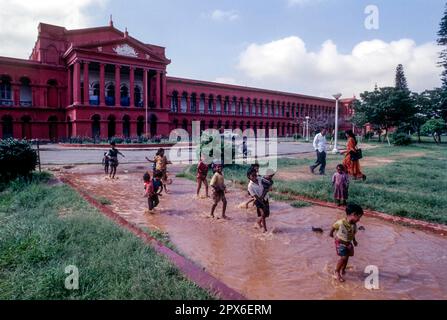 Kinder, die vor dem High Court in Bengaluru Bangalore, Karnataka, Südindien, Indien, Asien spielen. Korinthische Säulen in der Gotik Stockfoto