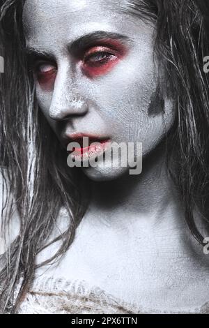 Ein Mädchen in Form von Zombies, eine Halloween-Leiche mit Blut auf seinen Lippen. Bild für einen Horrorfilm. Im Studio aufgenommene Fotos Stockfoto