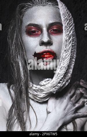 Ein Mädchen in Form von Zombies, eine Halloween-Leiche mit Blut auf seinen Lippen. Bild für einen Horrorfilm. Im Studio aufgenommene Fotos Stockfoto