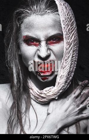 Ein Mädchen in Form von Zombies, eine Halloween-Leiche mit Blut auf seinen Lippen. Bild für einen Horrorfilm. Im Studio aufgenommene Fotos Stockfoto