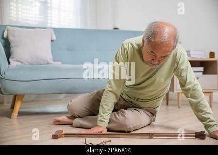 Älterer Senioren Kopfschmerzen, die nach dem Sturz auf dem Boden lagen, Schmerzen und Schmerzen durch Osteoporose, älterer Mann, der allein mit Gehhilfe auf den Boden fällt Stockfoto