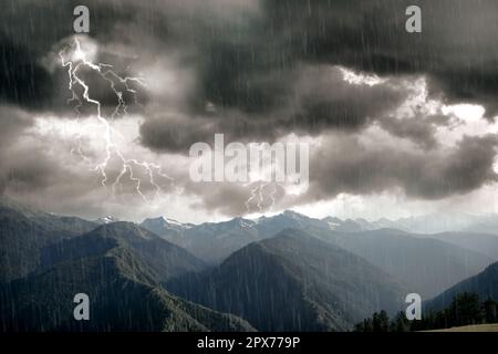 Dunkler bewölkter Himmel mit Licht und Regen über wunderschönen Bergwäldern. Gewitter Stockfoto